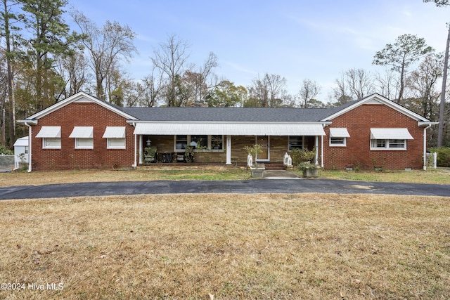 single story home featuring covered porch and a front yard