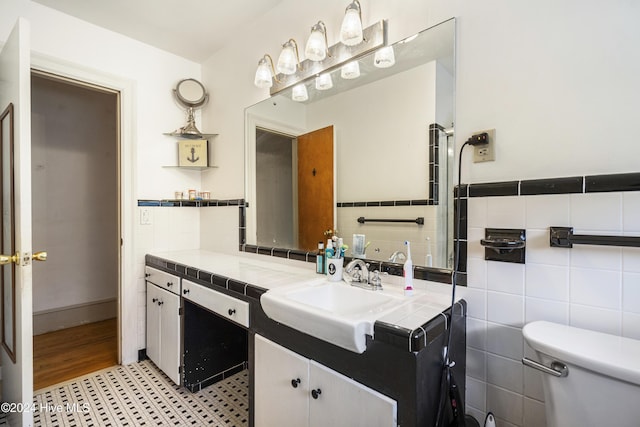 bathroom with hardwood / wood-style floors, vanity, toilet, and tile walls