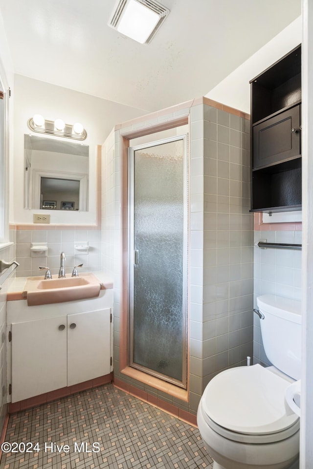 bathroom featuring vanity, toilet, tile walls, tasteful backsplash, and an enclosed shower