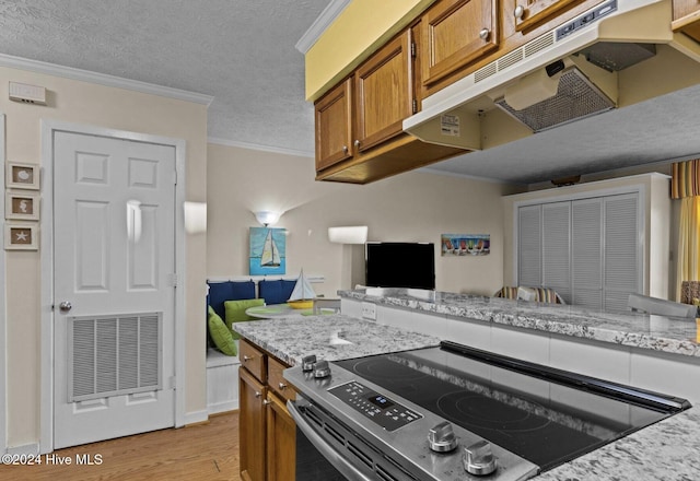 kitchen with stainless steel electric range, light stone countertops, ornamental molding, a textured ceiling, and light wood-type flooring