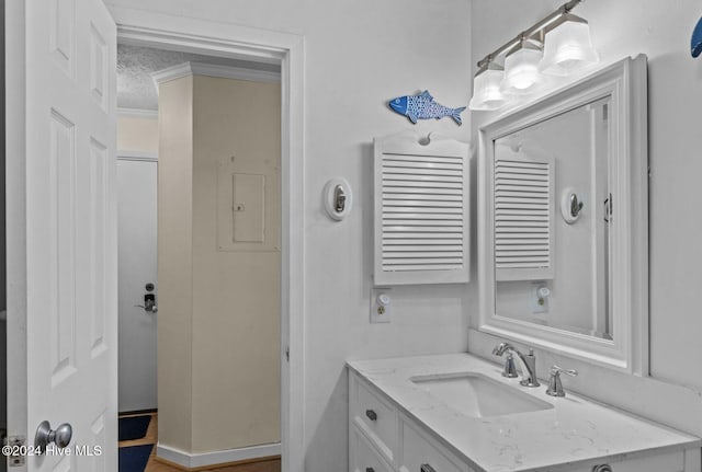 bathroom featuring vanity, ornamental molding, and a textured ceiling