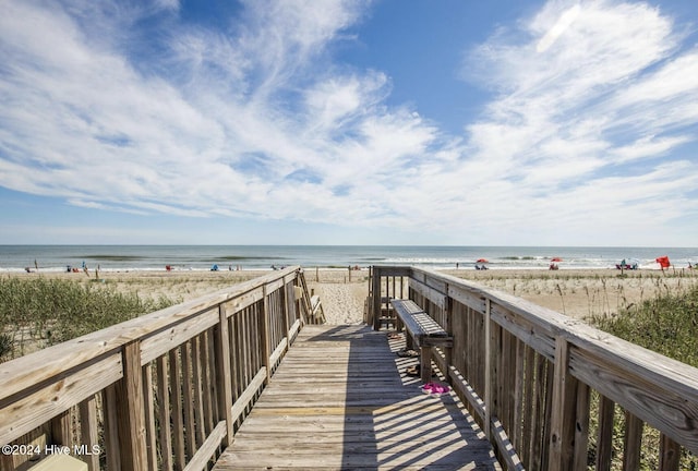 view of community with a water view and a beach view