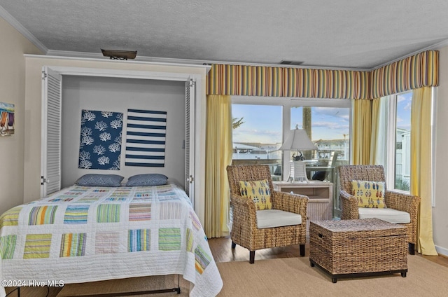 bedroom with a textured ceiling, light hardwood / wood-style flooring, and ornamental molding