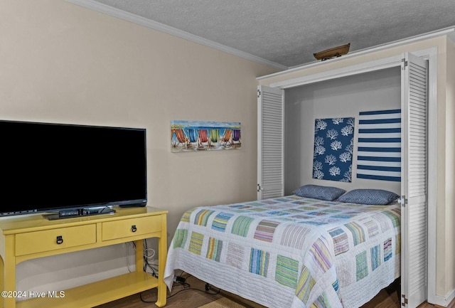 bedroom with a textured ceiling and crown molding