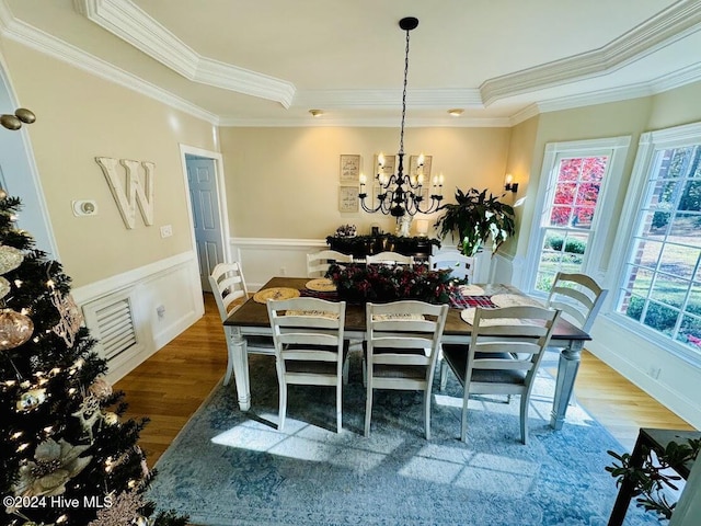 dining room with crown molding, a chandelier, and hardwood / wood-style flooring