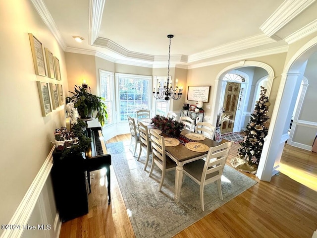 dining space with hardwood / wood-style floors and crown molding