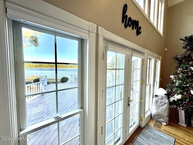 doorway with a water view, wood-type flooring, and french doors