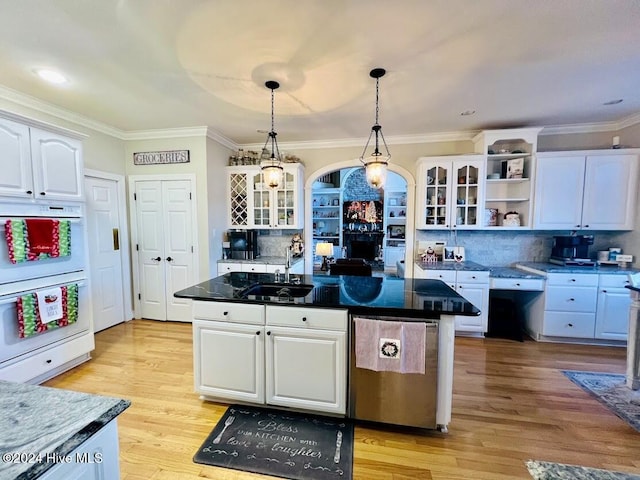 kitchen featuring decorative backsplash, white cabinetry, sink, and light hardwood / wood-style flooring