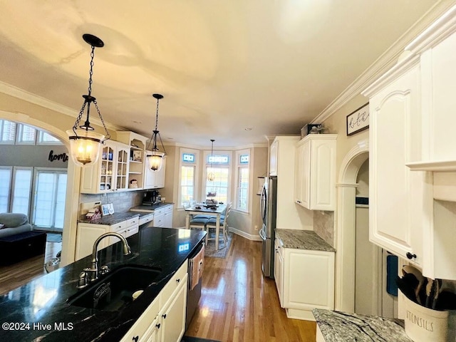 kitchen featuring sink, white cabinetry, a wealth of natural light, and dark stone countertops