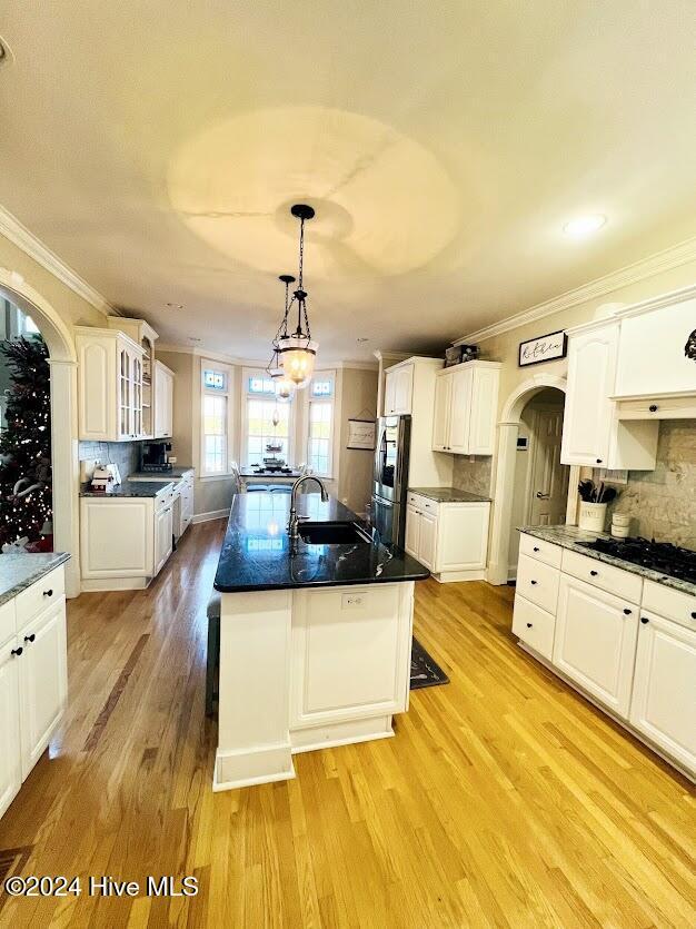 kitchen featuring tasteful backsplash, stainless steel fridge, light hardwood / wood-style flooring, and pendant lighting