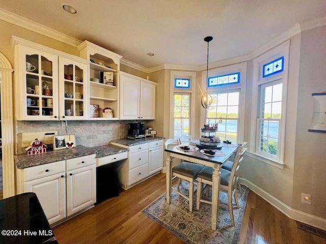 kitchen featuring a water view, white cabinets, wood-type flooring, and decorative light fixtures