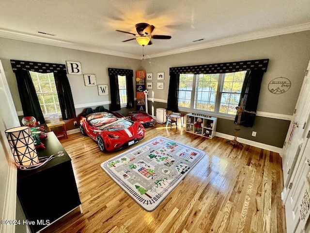 living room featuring hardwood / wood-style floors, ceiling fan, and crown molding