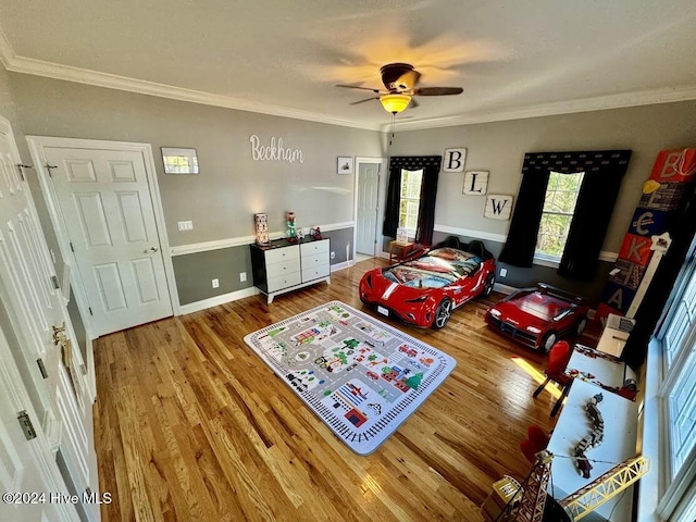 bedroom featuring hardwood / wood-style floors, ceiling fan, and crown molding