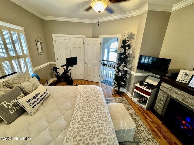 bedroom with wood-type flooring, crown molding, and a closet