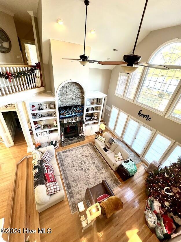 living room featuring ceiling fan, hardwood / wood-style floors, and high vaulted ceiling