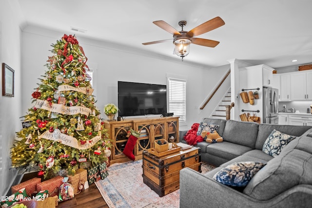 living room with ceiling fan, crown molding, and light hardwood / wood-style flooring