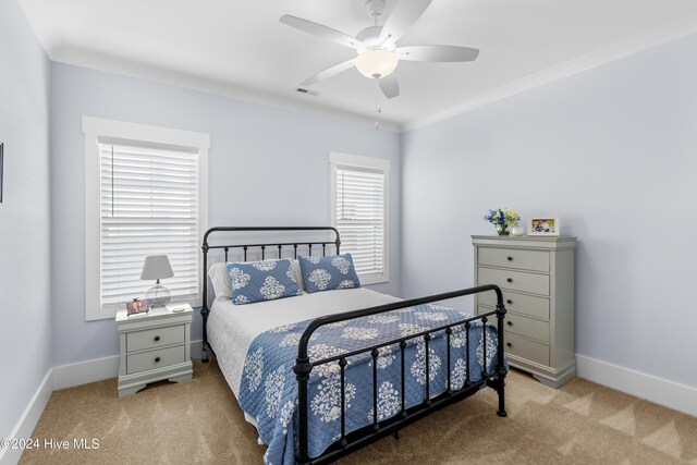 carpeted bedroom featuring ceiling fan and ornamental molding