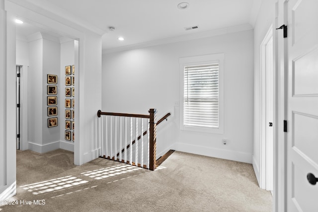 hall with crown molding and light carpet