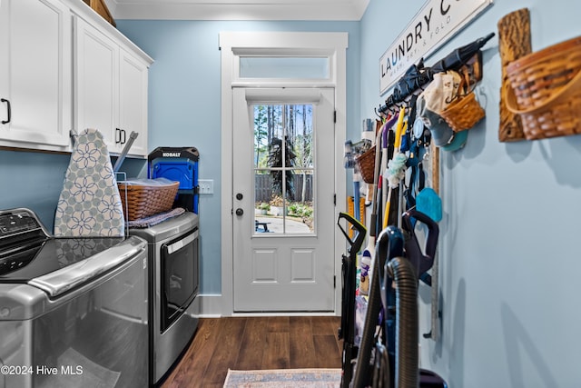 clothes washing area featuring washer and dryer, dark hardwood / wood-style floors, and cabinets