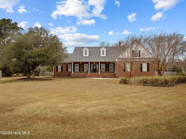 cape cod house featuring a porch and a front lawn