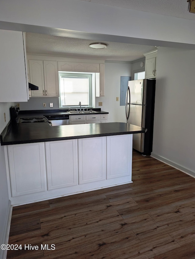 kitchen with kitchen peninsula, appliances with stainless steel finishes, a textured ceiling, dark hardwood / wood-style floors, and white cabinetry