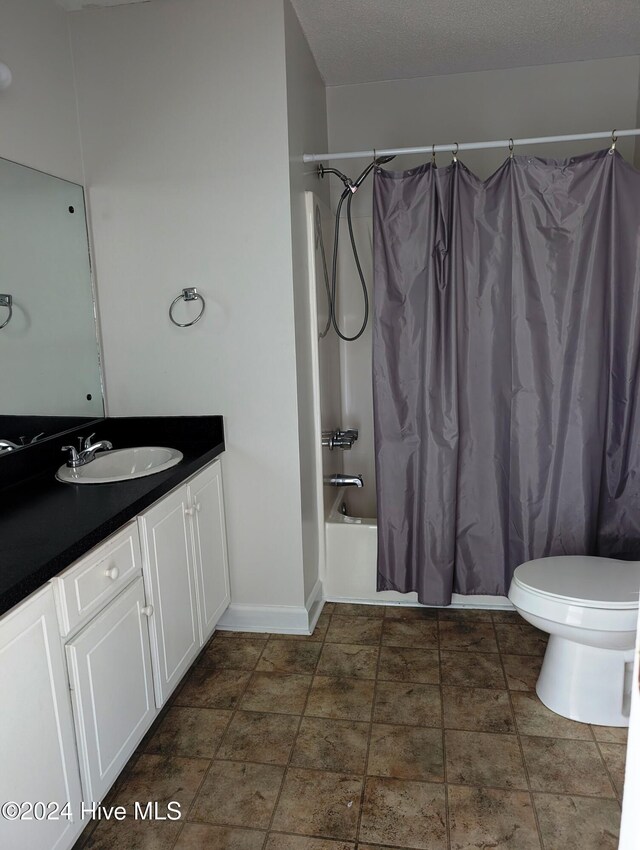 full bathroom with shower / bath combination with curtain, toilet, a textured ceiling, and vanity