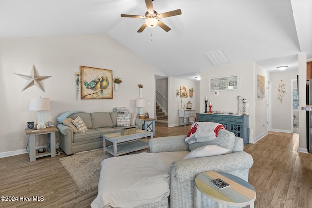 living room with ceiling fan, vaulted ceiling, and light hardwood / wood-style flooring