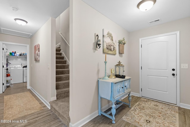 foyer entrance with washing machine and dryer and wood-type flooring