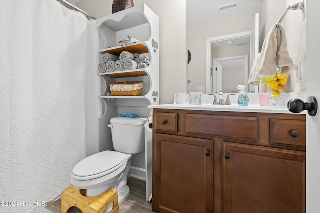 bathroom with wood-type flooring, vanity, and toilet