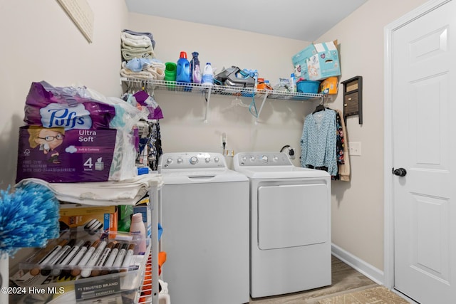 clothes washing area with hardwood / wood-style flooring and independent washer and dryer