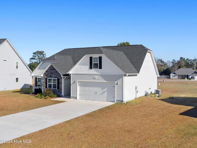 view of front of home with a front lawn, a garage, and central AC unit