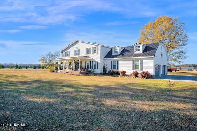 view of front of property featuring a front yard, a garage, and covered porch