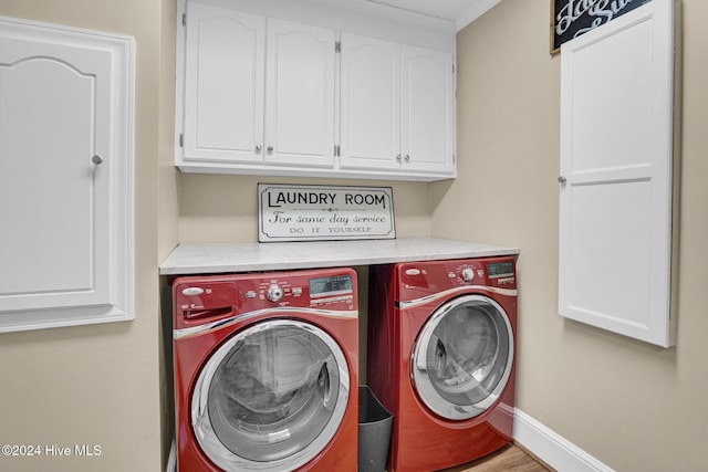 laundry room featuring washer and dryer, ornamental molding, cabinets, and wood-type flooring