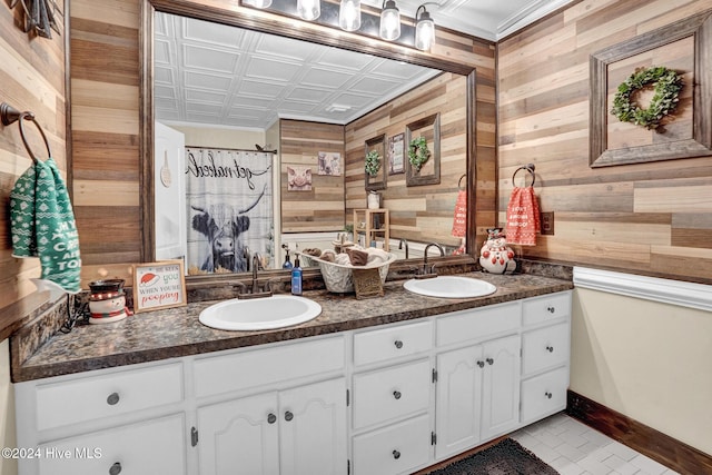 bathroom with tile patterned floors, wood walls, curtained shower, and vanity