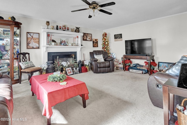 carpeted living room featuring ceiling fan, ornamental molding, and a tile fireplace