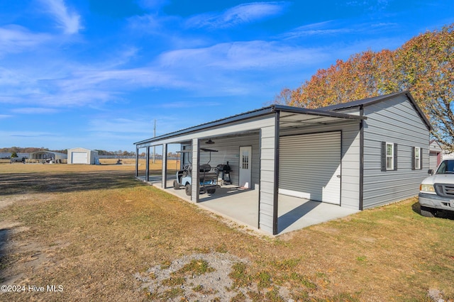 view of outbuilding with a yard, a garage, and a carport