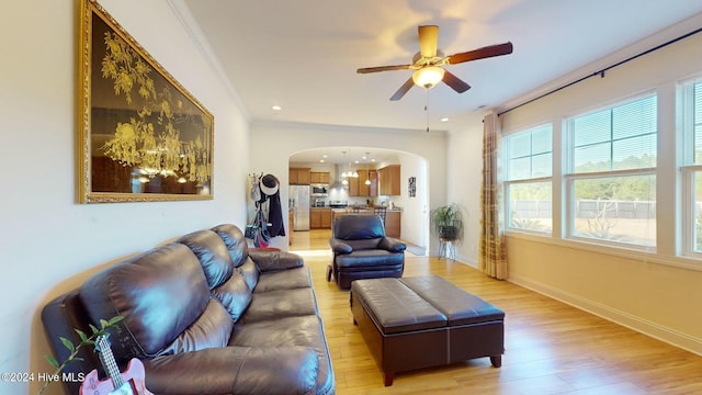 living room featuring light wood-type flooring, ceiling fan, and ornamental molding