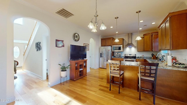 kitchen featuring a center island, sink, wall chimney exhaust hood, light wood-type flooring, and stainless steel appliances