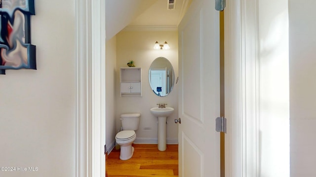 bathroom featuring hardwood / wood-style flooring, toilet, crown molding, and sink