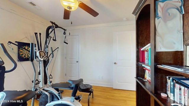 workout area featuring light wood-type flooring and ceiling fan