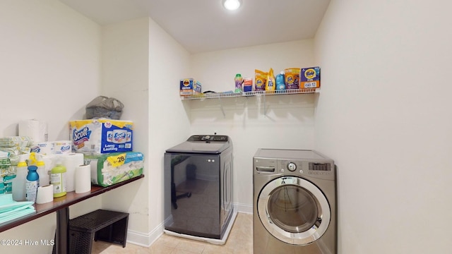 washroom featuring light tile patterned flooring and washer and dryer