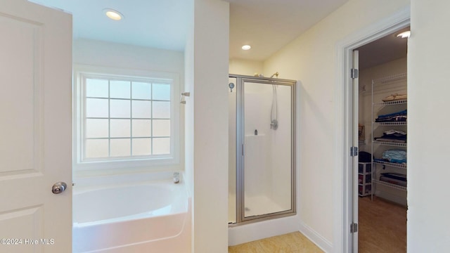 bathroom featuring independent shower and bath and a wealth of natural light