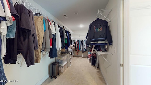 walk in closet featuring light carpet