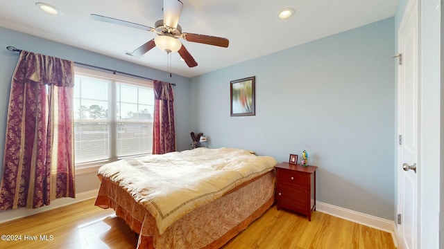 bedroom with ceiling fan and light hardwood / wood-style flooring