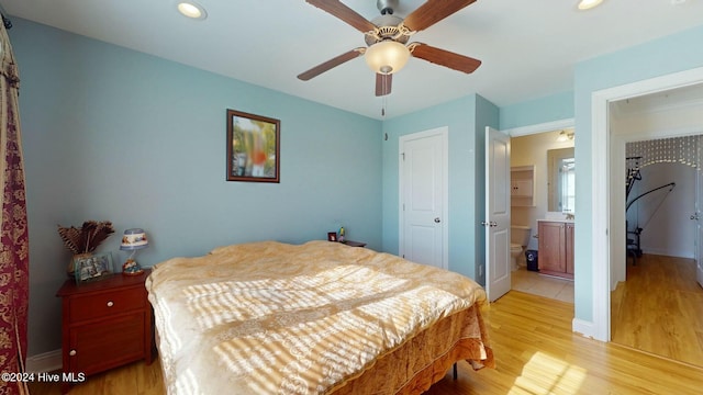 bedroom featuring ceiling fan, light wood-type flooring, and connected bathroom