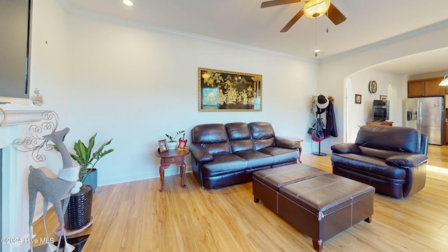 living room with ceiling fan, light wood-type flooring, and crown molding