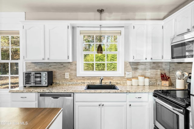 kitchen featuring white cabinets, backsplash, sink, and appliances with stainless steel finishes