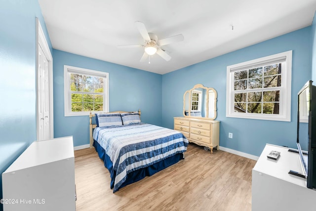 bedroom featuring ceiling fan, light hardwood / wood-style floors, and a closet