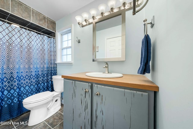 bathroom featuring tile patterned flooring, a shower with curtain, vanity, and toilet