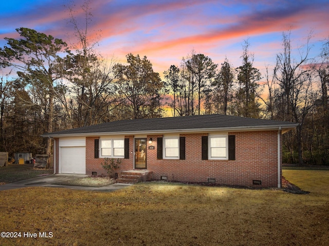 ranch-style home with a lawn and a garage